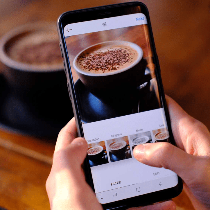 Emprendedor tomando foto a un cafe para su cuenta d e instagram
