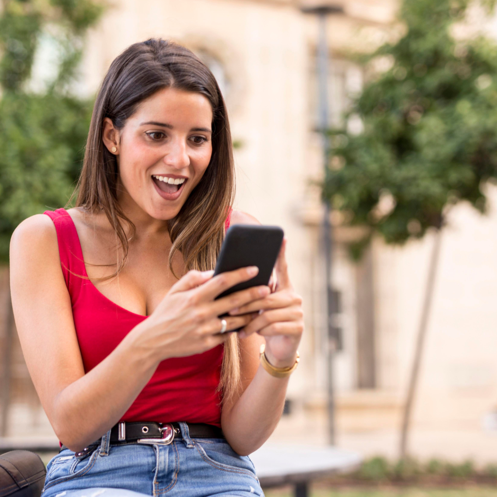 mujer interactúando con un celular en su mano